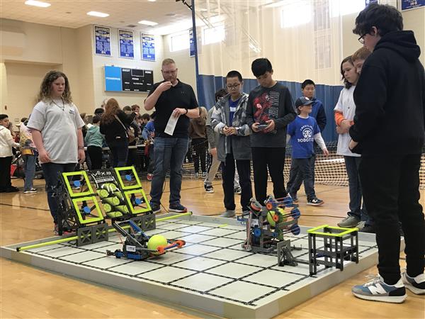 Students control a robot at a VEX IQ Robotics competition.